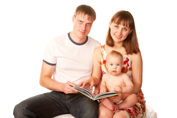 Happy family reading a book and smiling. — Stock Photo, Image