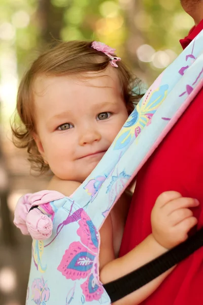 Happy baby sitting in a carrying sling. — Stock Photo, Image