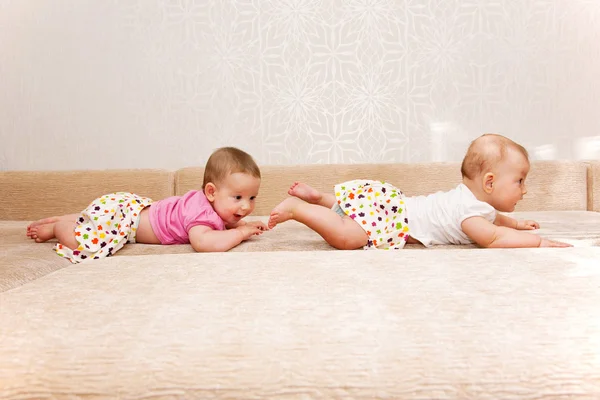 Två baby tvillingar kryper efter varandra — Stockfoto