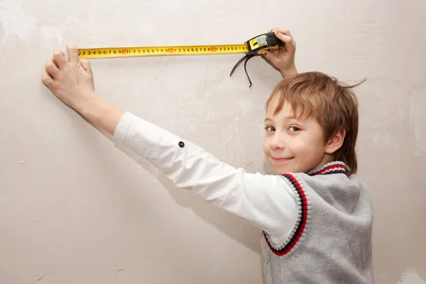 Маленький хлопчик щось вимірює стрічку — стокове фото