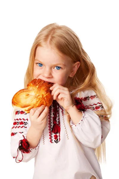 Bun büyük iştahla yiyen küçük kız. — Stok fotoğraf