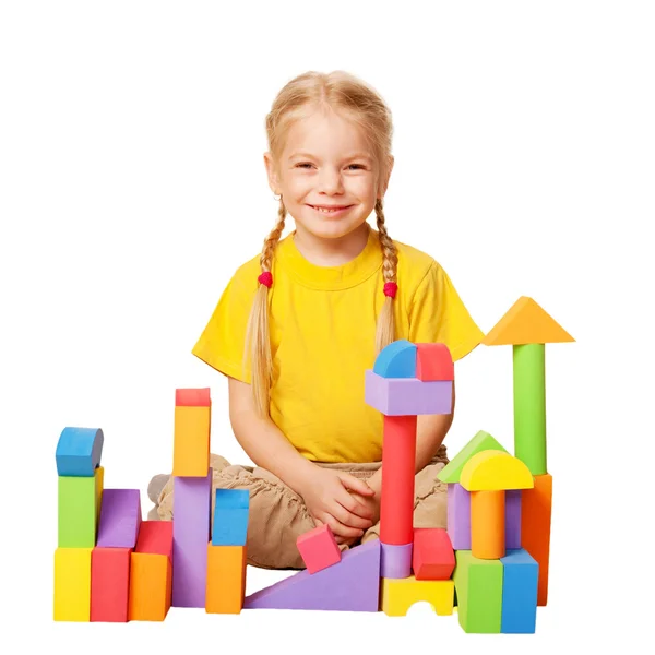 Petite fille heureuse construisant des maisons à partir de blocs de jouets de couleur . — Photo