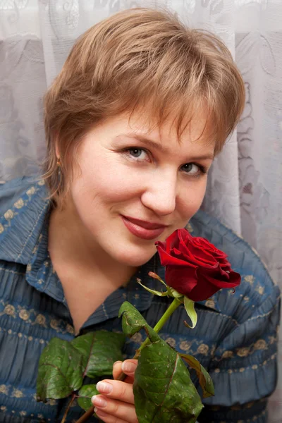 Middle-aged woman with a rose. — Stock Photo, Image