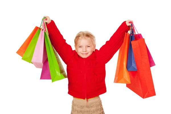 Einkaufskind. glückliches kleines Mädchen hält Einkaufstüten hoch. — Stockfoto