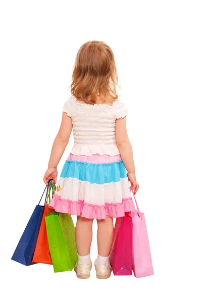 Küçük kız alışveriş torbaları yürüme. arka görünüm. — Stok fotoğraf
