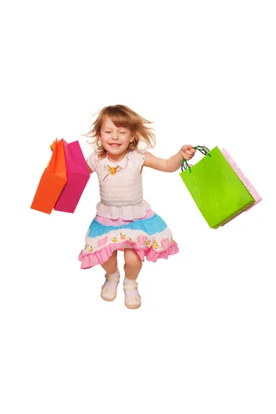 Happy little girl running and jumping with shopping bags. — Stock Photo, Image