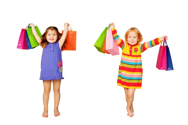 Kinderen winkelen. twee kleine meisjes met hun aankopen en giften. — Stockfoto