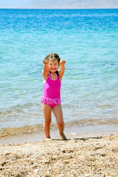 Pequeña gir jugando con la arena en la playa . —  Fotos de Stock