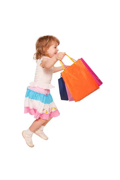 Feliz niña corriendo y saltando con bolsas de compras —  Fotos de Stock