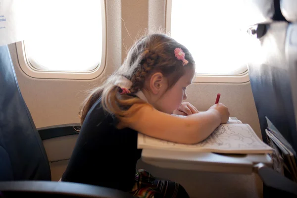 Little girl drawing and flying by plane — Stock Photo, Image