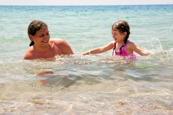 Father and baby daughter playing in the water. — Stock Photo, Image