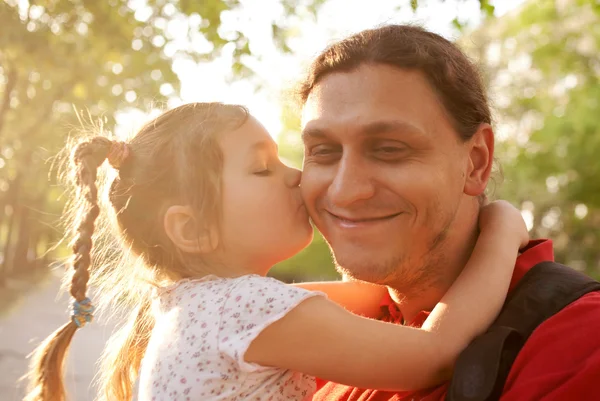 Little daughter kissing father. Happy family outdoors. — Stock Photo, Image