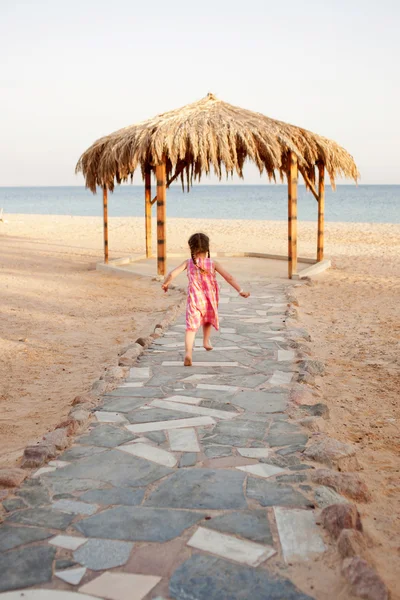 Kleines Mädchen, das zum Meer läuft. Rückansicht. — Stockfoto