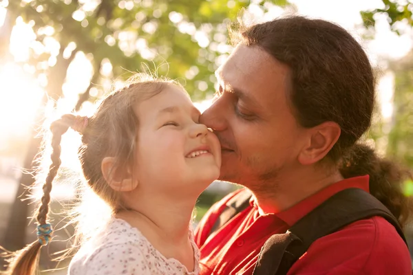 Far kysser dotter. lycklig familj utomhus. — Stockfoto