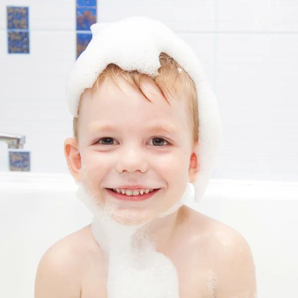 Little child in a cap of foam soap smiling — Stock Photo, Image