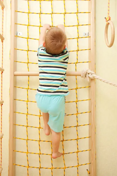 Niño trepando en una red de cuerda . — Foto de Stock