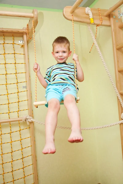 Petit garçon faisant du sport, balançant sur swing — Photo