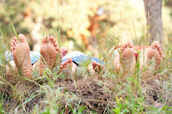 Pies de padre, madre e hijo en la hierba . — Foto de Stock