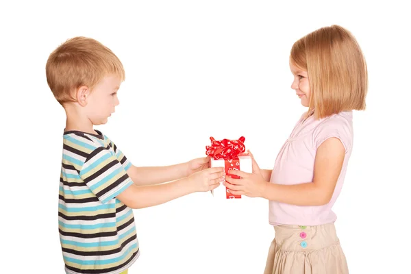 Kleiner Junge macht einem kleinen Mädchen ein Geschenk. — Stockfoto