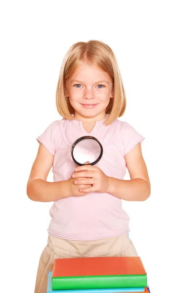 Little girl with books and magnifying glass. — Stock Photo, Image