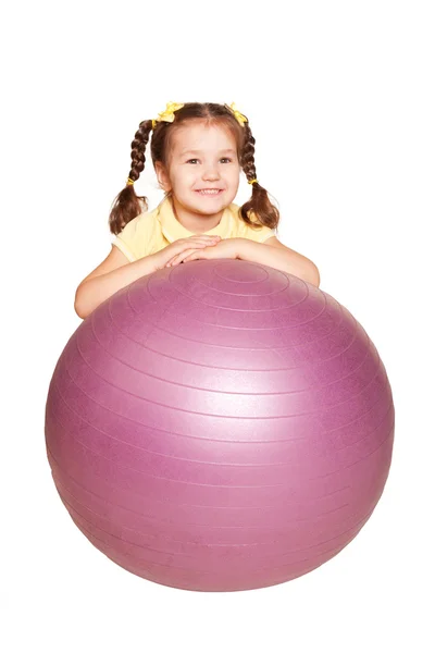 Pigtails ve fitness topu ile küçük kız gülümseyerek. — Stok fotoğraf