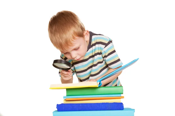 Pequeño niño leyendo libro con lupa — Foto de Stock