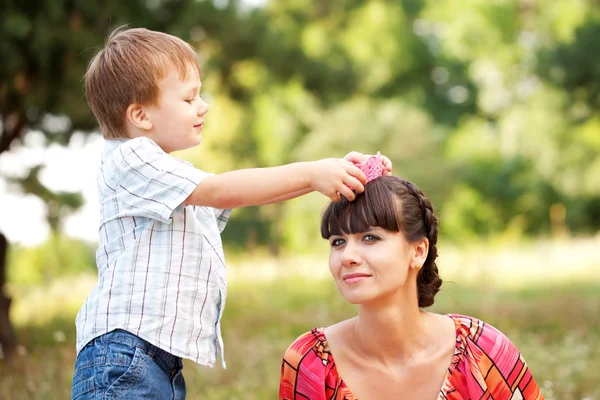 Sohn setzt seiner Mutter eine gestrickte Krone auf. — Stockfoto