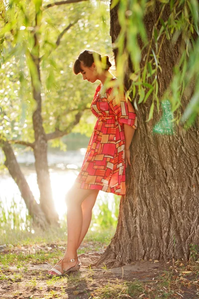 Una mujer solitaria de pie cerca del árbol — Foto de Stock