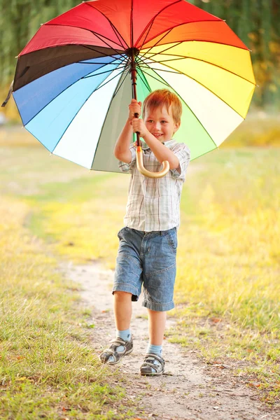 Adorabile ragazzo con ombrello colorato — Foto Stock