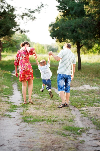 Père, mère et fils marchant à l'extérieur . — Photo