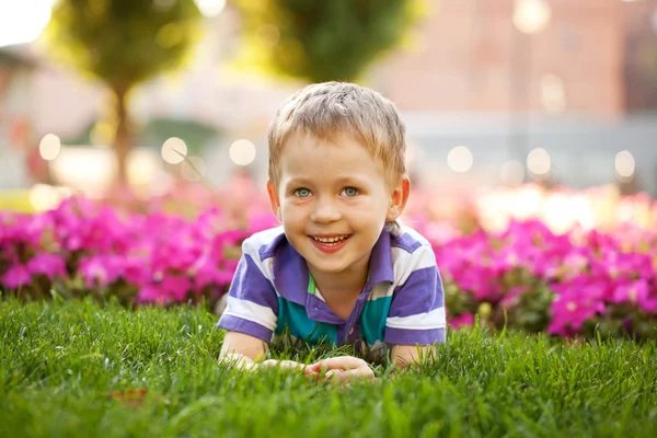 Liten pojke bland blommorna — Stockfoto