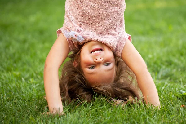 Menina feliz de pé em sua cabeça — Fotografia de Stock