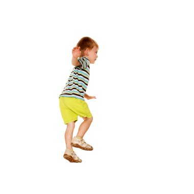 Happy little boy in a striped T-shirt dancing. clipart