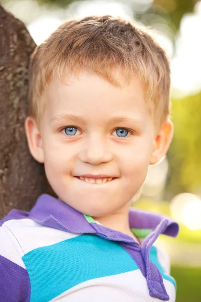 Pequeño niño oliendo flor de cerca . — Foto de Stock