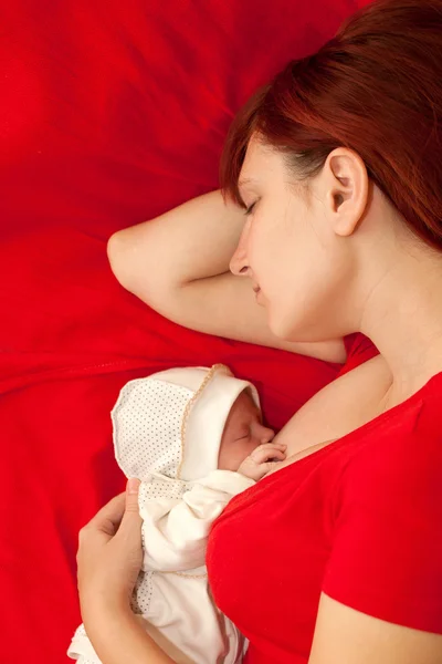 Boldog anya és a baba alszik az ágyban. — Stock Fotó