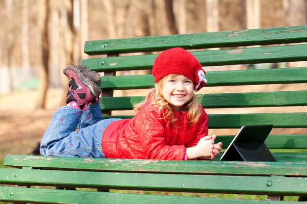 Lachende blij meisje met behulp van Tablet PC buitenshuis. — Stockfoto