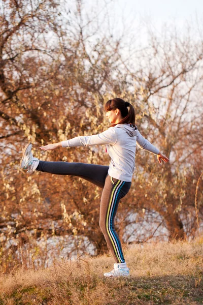 Mujer haciendo ejercicios de yoga al atardecer al aire libre . — Foto de Stock