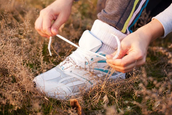 Manos atando los cordones en los zapatos deportivos —  Fotos de Stock