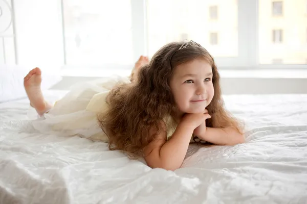 Sonhe com a pequena princesa em uma cama branca close-up . — Fotografia de Stock