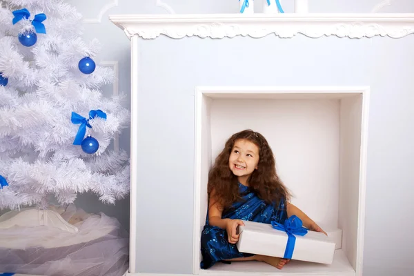 Glückliches Kind im Kamin wartet auf Geschenke. — Stockfoto