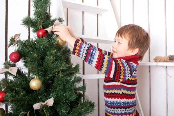 Joyeux enfant décorant le sapin de Noël avec des boules . — Photo