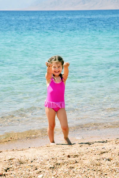 Šťastná holčička na pláži hraje — Stock fotografie