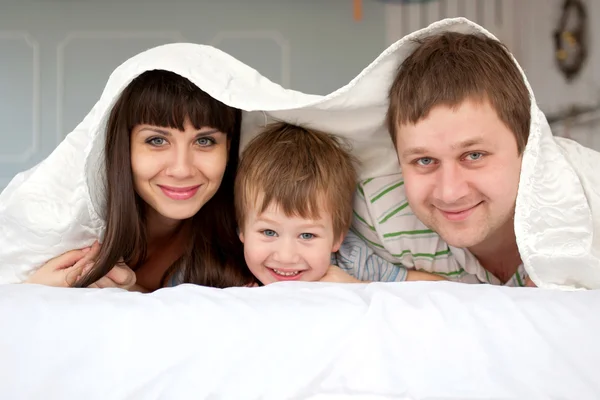 Família descansando na cama juntos — Fotografia de Stock