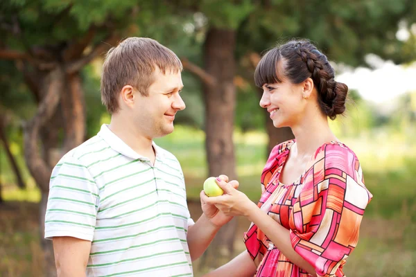 Happy middle aged couple with apple. — Stock Photo, Image