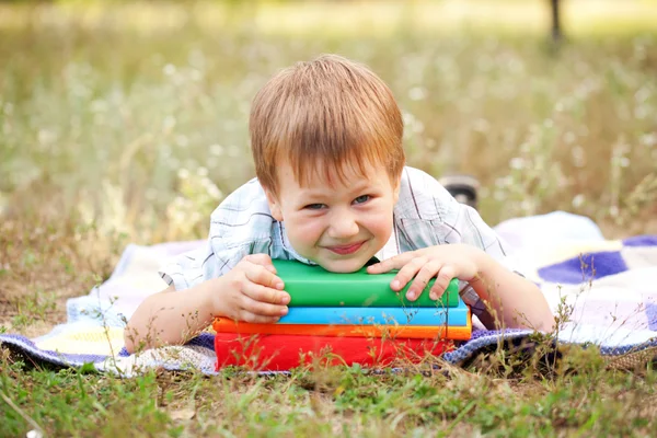 Liten pojke och böcker utomhus. tillbaka till skolan. — Stockfoto