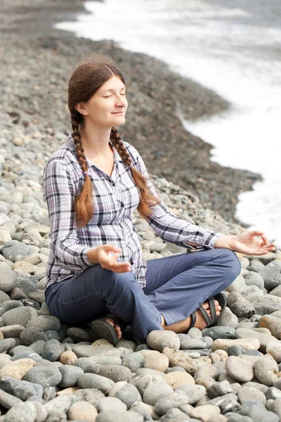 Terhes nő lazítson a strandon jóga — Stock Fotó