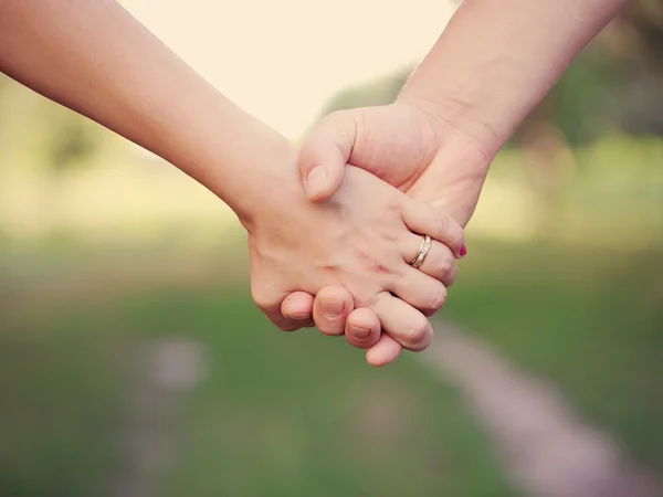 Dos personas cogidas de la mano al aire libre . —  Fotos de Stock