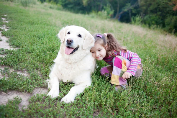 Criança pequena feliz abraçando golden retriever — Fotografia de Stock