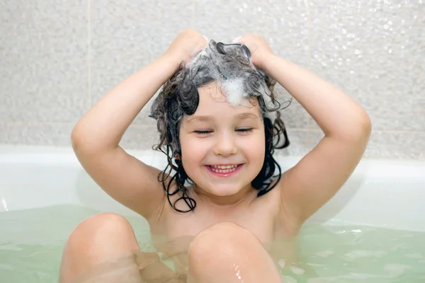Criança pequena feliz que toma banho na banheira — Fotografia de Stock