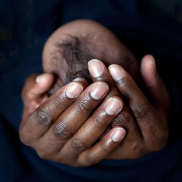 Schwarzer Vater hält Neugeborenes in der Hand — Stockfoto